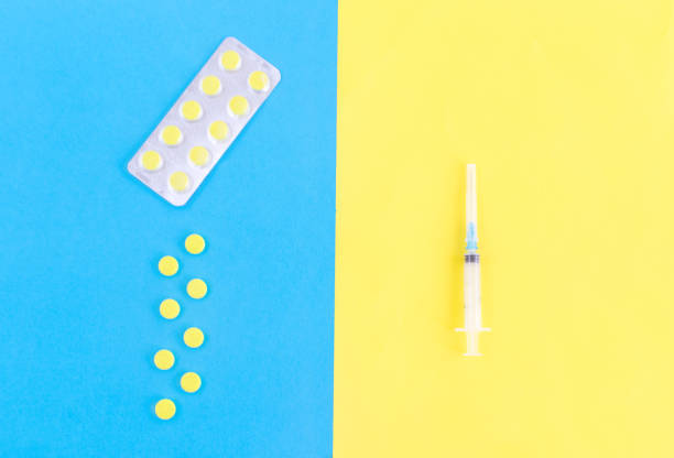 istock Syringe and various tablets and capsules isolated on yellow and blue background.concept of medicine.Medicines for the treatment of diseases, viruses, autumn cold, beriberi, hypothermia, vaccination 1170997664