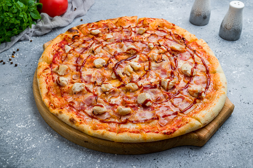 Pizza with chicken and bacon and barbecue sauce on beautiful grey table