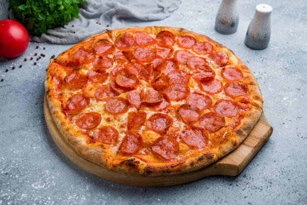 istock Pepperoni pizza on board on beautiful grey table 1170998076