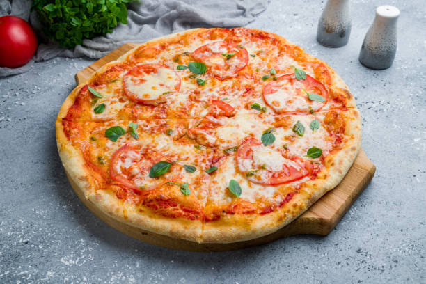 istock Italian pizza Margherita with tomatoes and basil on beautiful grey table 1170998684