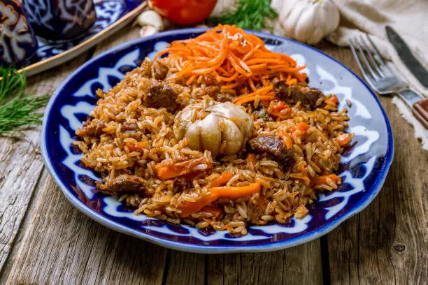 pilaf with beef on wooden background
