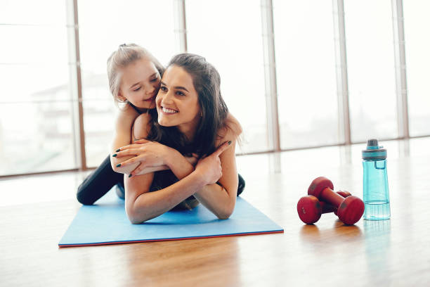 istock Mother and daughter training in a gym 1171001966