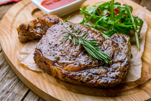 istock juicy Ribeye steak on wooden background 1171002210
