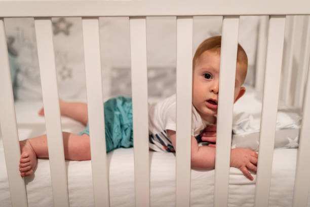 istock Cute baby boy lying down in the crib 1171002919