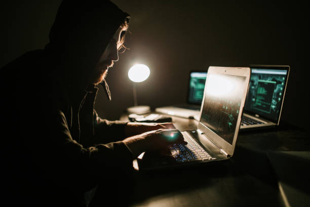 istock Hacker working in the dark room and stealing information 1171004731