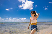 夏に浜辺を歩く若い女性