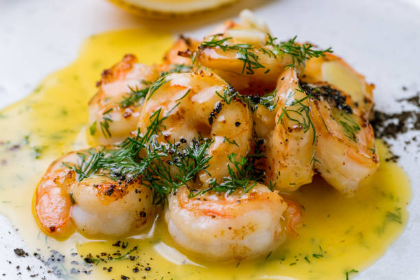 istock Tiger prawns on the grill with sause and greens on white concrete table 1171012049
