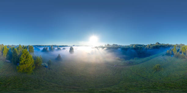 360-degree panoramic aerial view of the field, forest and river covered with a thick layer of morning fog