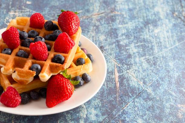 istock Classic Berry Waffles on a Rustic Blue Wood Table 1171017908