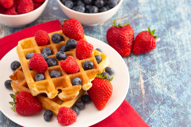 istock Classic Berry Waffles on a Rustic Blue Wood Table 1171017909