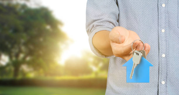 istock Hand holding house key, real estate agent 1171019658