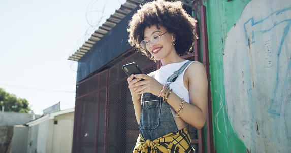 Shot of an attractive young woman using a smartphone in an urban setting