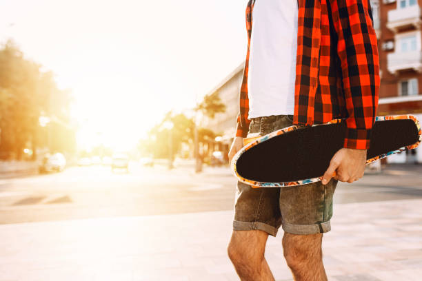 istock guy with a beard with a skateboard at sunset. 1171026074