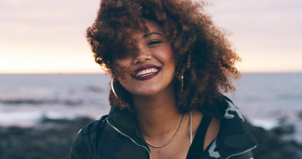Shot of an attractive young woman enjoying time on the beach at sunset