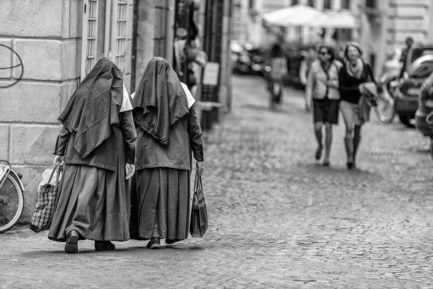 The historic city of Rome in the Italian province of Lazio on November 07, 2013: Nuns walking down the cobbled streets of the Centro Storico area of Rome Italy