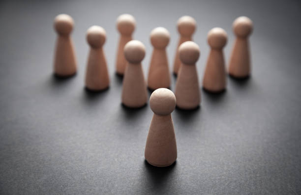 istock Wooden human figures on the black background. Leader 1171040958