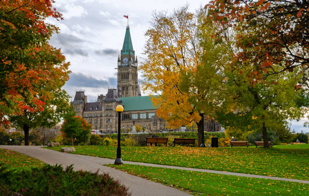 edifici del parlamento in colori autunnali a ottawa, canada - autumn clock roof colors foto e immagini stock