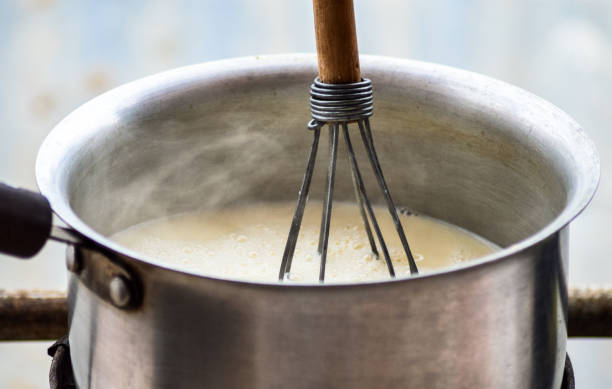 Boil organic raw milk in a stainless steel saucepan and mix with a manual egg thresher.