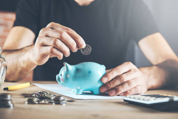 istock man hand piggy bank with coins 1171045780