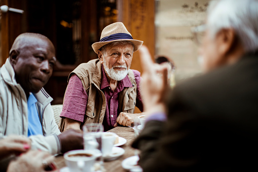 Close up of a group of seniors relaxing in a cafe after exploring the city