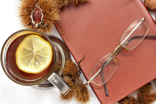 istock Composition. Tea with lemon, a closed book, glasses and chestnuts 1171047955