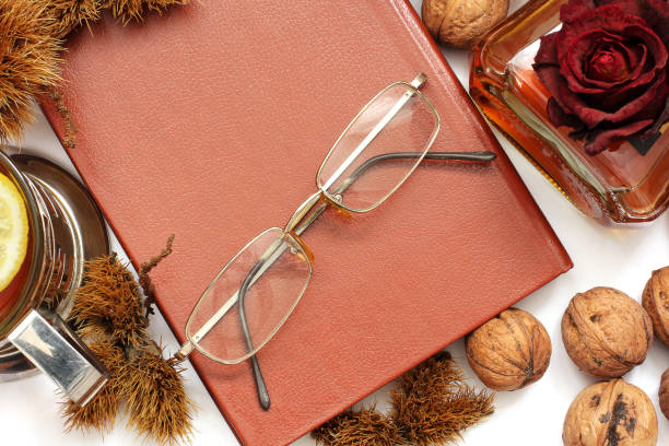 istock Composition. Cognac, a closed book, glasses and chestnuts 1171048023