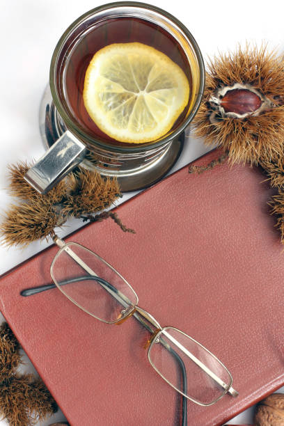 istock Composition. Tea with lemon, a closed book, glasses and chestnuts 1171048047