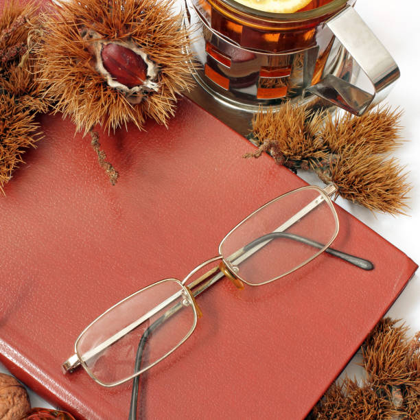 istock Composition. Tea with lemon, a closed book, glasses and chestnuts 1171048083