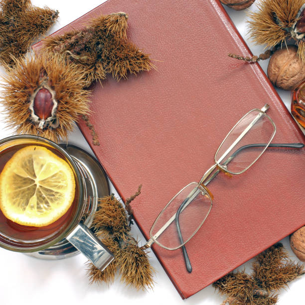 istock Composition. Tea with lemon, a closed book, glasses and chestnuts 1171048128