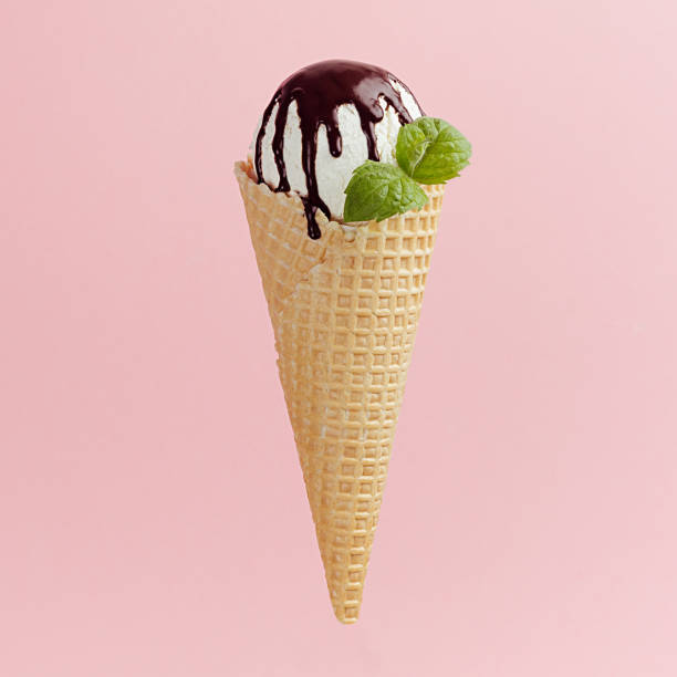 istock Classic white ice cream in crisp waffle cone with chocolate sauce, mint leaf on pink background, square, closeup. 1171059454
