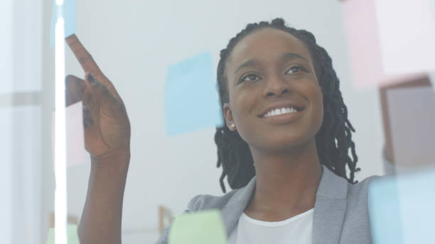 istock Afro Business Lady Reading Sticky Notes On Glass Visualisation Board 1171060438