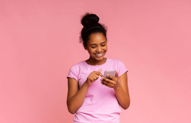 istock Cool Application. Interested Girl Using Smartphone on Pink Background 1171060456