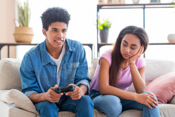 カップルの危機。ガールフレンドに注意を払っていない、ビデオゲームをプレイする男 - african descent addiction african ethnicity rudeness ストックフォトと画像