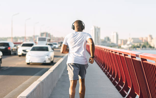istock Sporty black guy running along the bridge 1171060727