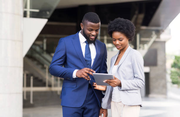 istock Business people using digital tablet together outdoors 1171061283