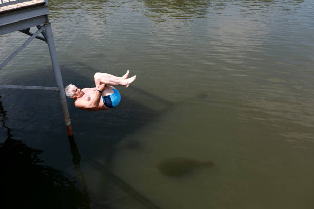 istock Senior man dives into river from bridge 1171061371