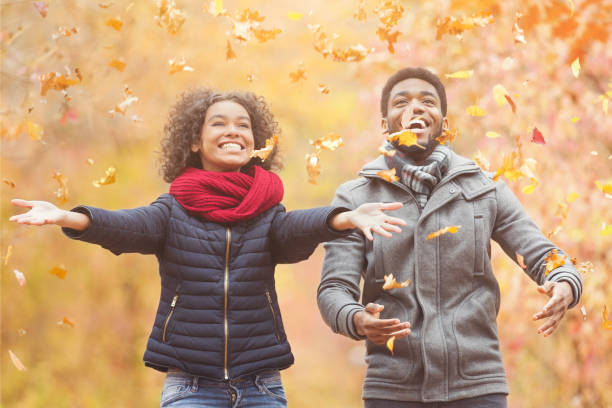 istock Happy afro couple throwing autumn fall leaves 1171062133