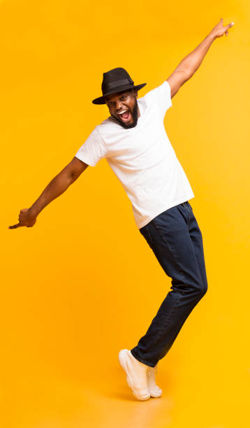 istock Funny Black Guy Fooling, Standing on Tiptoes Over Yellow Background 1171062907