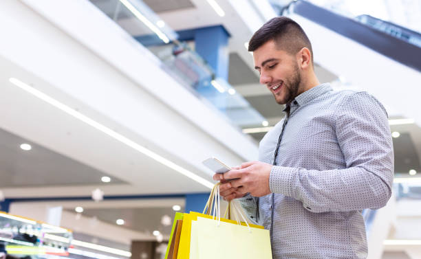 istock Handsome man using phone, shopping in mall 1171062935