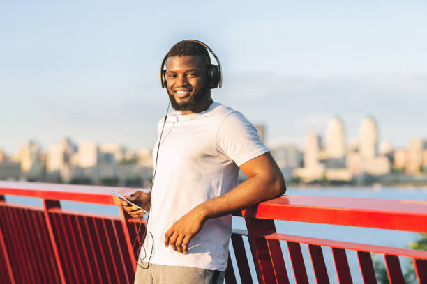 istock Handsome afro sportsman smiling at camera, staying on bridge 1171063214