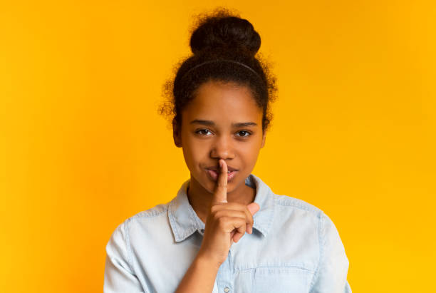 istock Beautiful black girl put finger on lips, making hush sign 1171063909