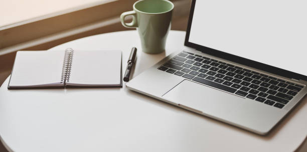 istock Cropped view of minimal workplace with open blank screen laptop 1171064315