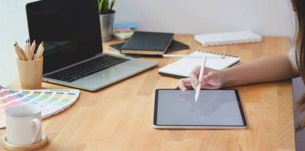 istock Young passionate female freelancer writing her idea on tablet 1171064391