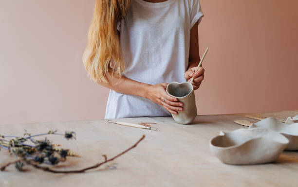 istock Unrecognizable woman working with clay mug standing at a table in studio 1171068588