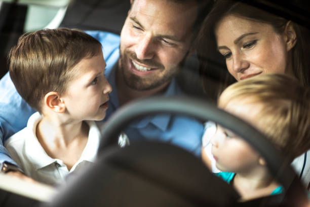 istock Two small boys with their parents sitting in a car together 1171069882