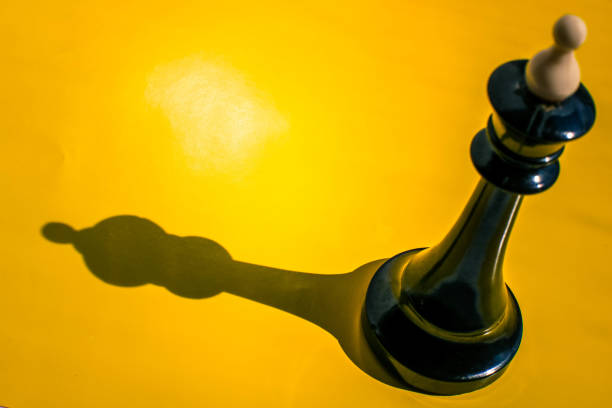 Chess piece king with shadow isolated on yellow background.