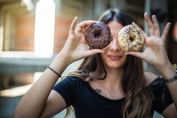 istock Happy woman holding donuts 1171072880