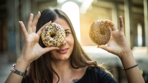 istock Happy woman holding donuts 1171072901
