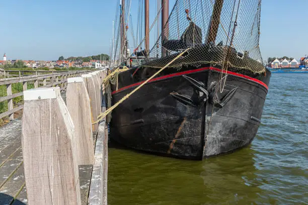 Bow of historic sailing ship moored at pier of Dutch fishing village Urk