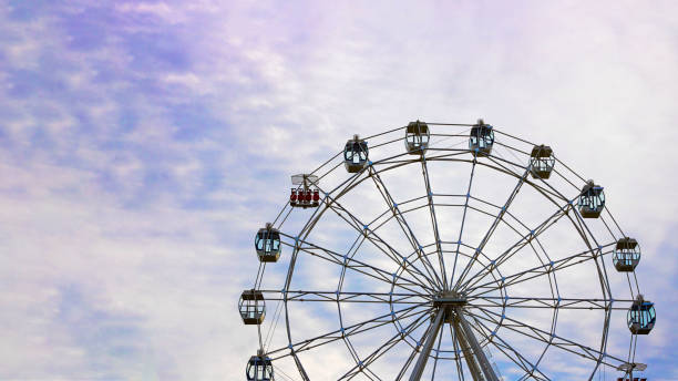 istock Empty Observation wheel on the background of blue sky with white clouds. Horizontal with copy space for text of design about theme park, amusement. Summer. Day time. 1171076584